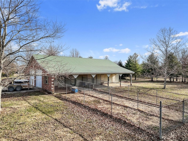 view of front of home featuring a carport, fence, and metal roof