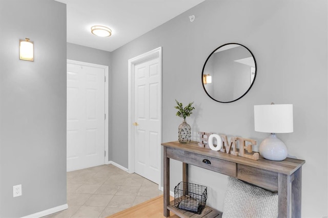 interior space featuring light tile patterned flooring and baseboards