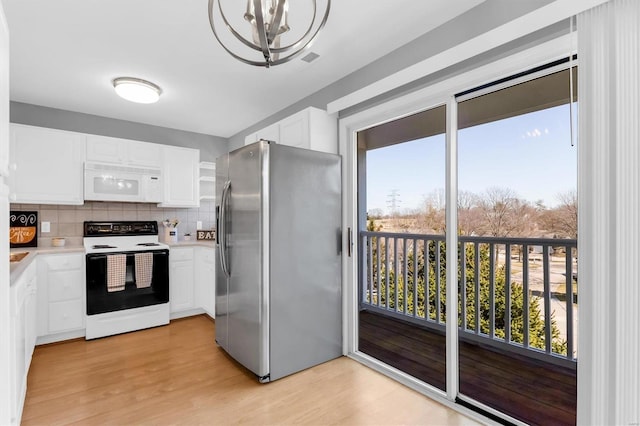 kitchen with white appliances, light wood finished floors, light countertops, white cabinetry, and backsplash