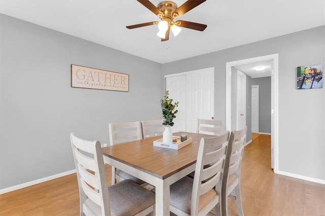 dining room with light wood-type flooring, baseboards, and a ceiling fan