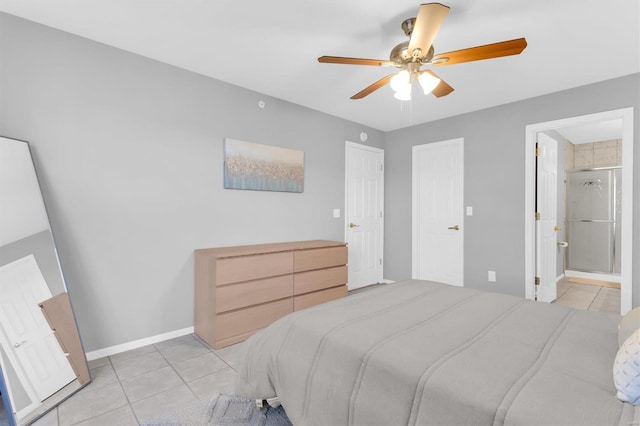 bedroom featuring light tile patterned floors, a ceiling fan, ensuite bath, and baseboards