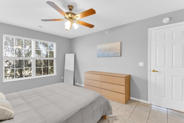 bedroom with light tile patterned flooring, visible vents, ceiling fan, and baseboards