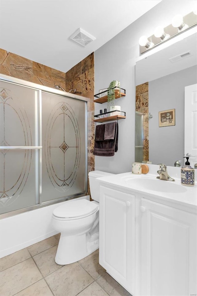 bathroom with visible vents, toilet, vanity, and shower / bath combination with glass door