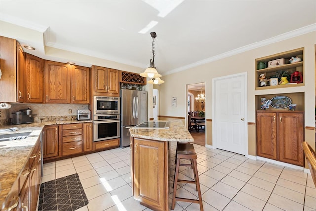 kitchen with light tile patterned flooring, appliances with stainless steel finishes, crown molding, a kitchen breakfast bar, and brown cabinets