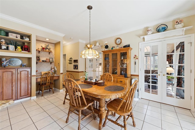 dining space with crown molding, light tile patterned flooring, french doors, and built in features