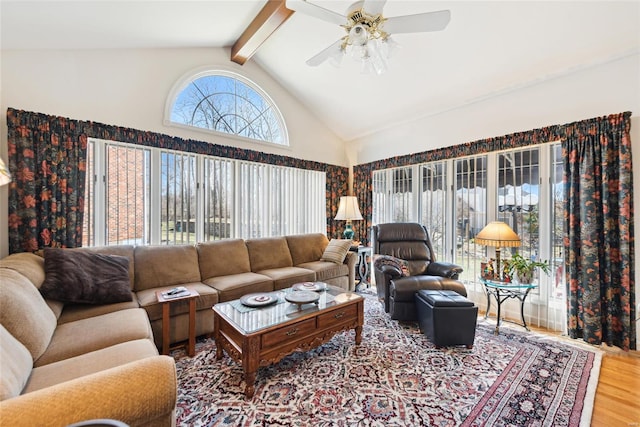 living room with beamed ceiling, high vaulted ceiling, a ceiling fan, and wood finished floors