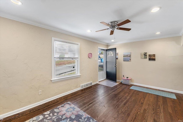 foyer featuring visible vents, baseboards, wood finished floors, and ornamental molding