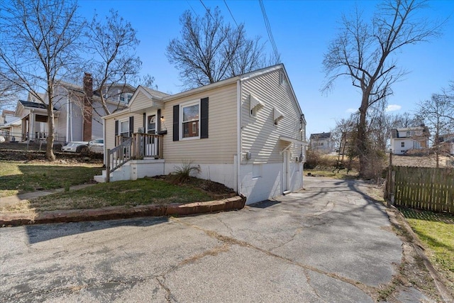 view of front of property featuring aphalt driveway and fence