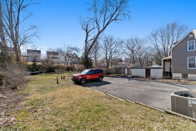 view of vehicle parking featuring driveway and fence