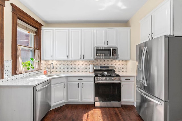 kitchen featuring a sink, appliances with stainless steel finishes, white cabinets, light countertops, and decorative backsplash