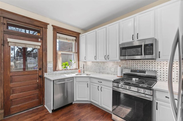 kitchen featuring light countertops, dark wood-style floors, tasteful backsplash, and appliances with stainless steel finishes