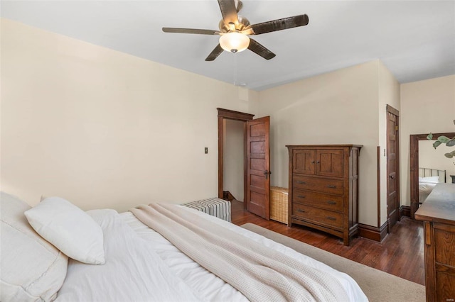 bedroom with a ceiling fan, dark wood-style floors, and baseboards