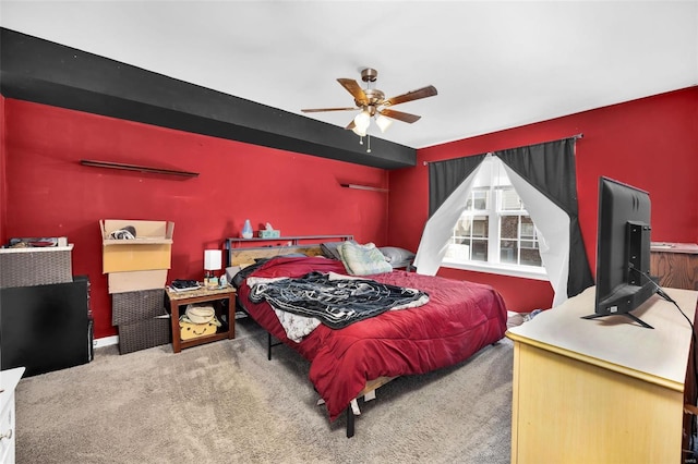 carpeted bedroom featuring a ceiling fan and an accent wall