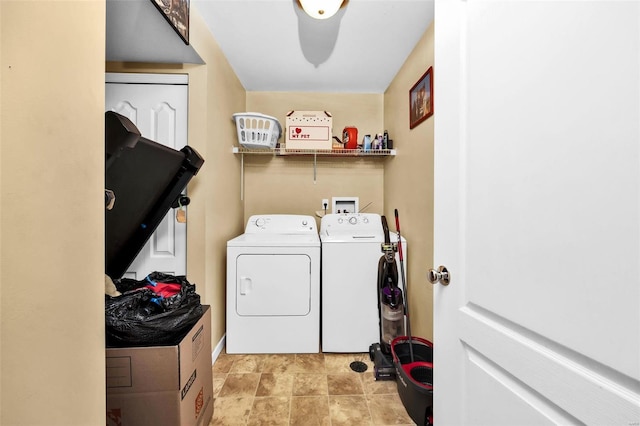 washroom with baseboards, laundry area, and washing machine and clothes dryer