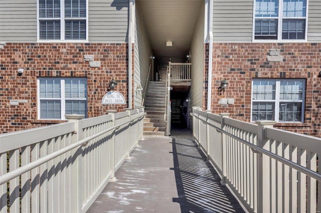 doorway to property featuring brick siding and fence