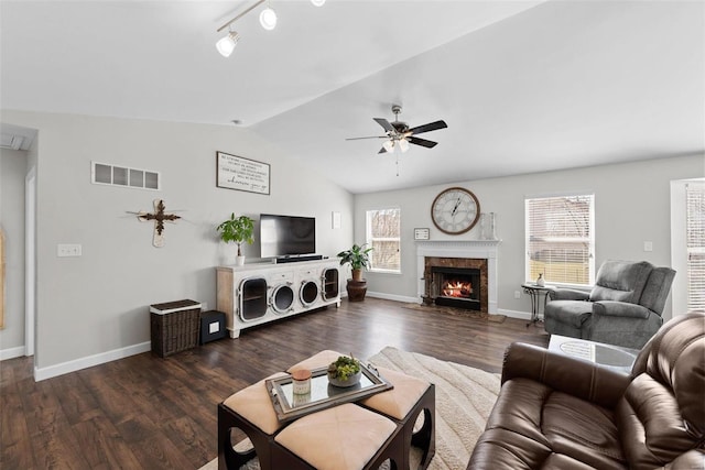 living room featuring a ceiling fan, lofted ceiling, wood finished floors, and visible vents