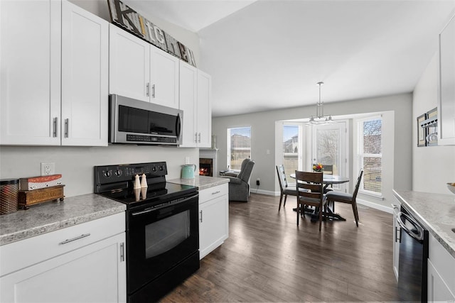 kitchen with baseboards, light countertops, dark wood-style floors, white cabinets, and black appliances