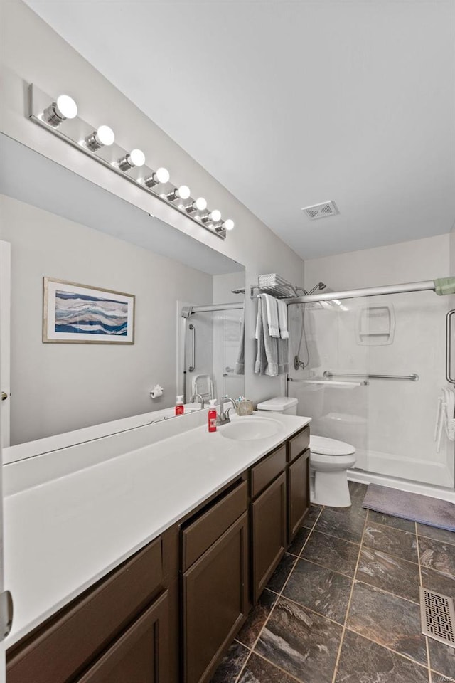 bathroom featuring vanity, a shower stall, toilet, and visible vents