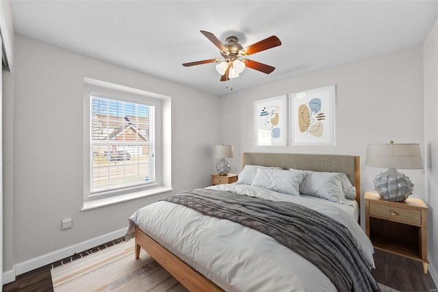 bedroom featuring ceiling fan, baseboards, and wood finished floors