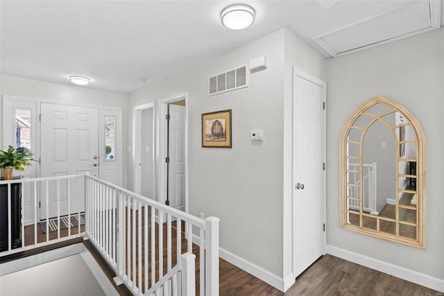 hall featuring an upstairs landing, visible vents, dark wood-type flooring, and baseboards