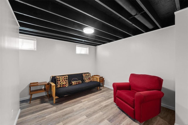 sitting room with a healthy amount of sunlight, baseboards, and wood finished floors