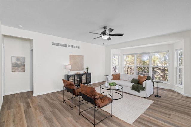 living room featuring visible vents, baseboards, and wood finished floors