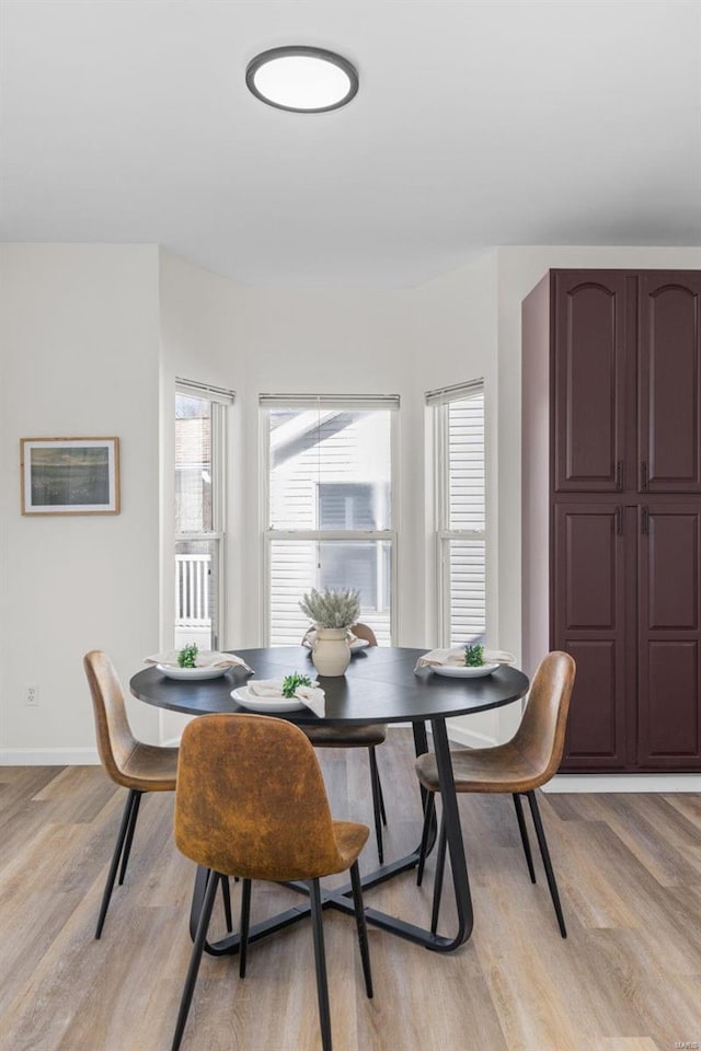 dining space with light wood-style floors and baseboards