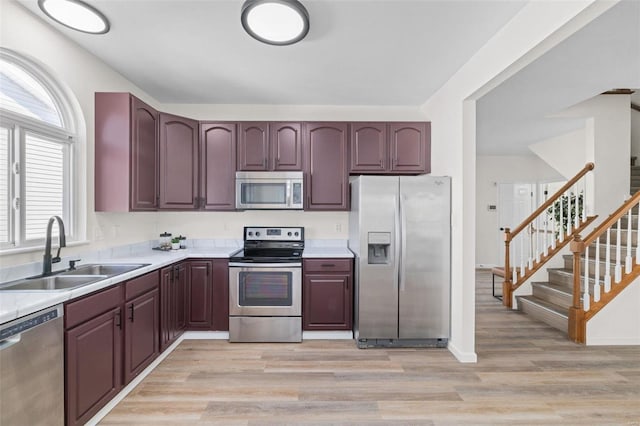 kitchen featuring a sink, light wood-type flooring, appliances with stainless steel finishes, and light countertops