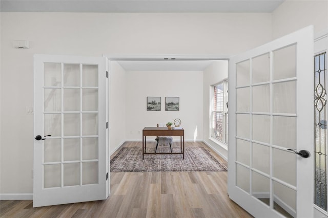 office area with wood finished floors, french doors, and baseboards