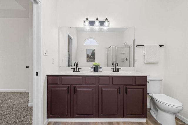 full bathroom with double vanity, a stall shower, toilet, and a sink