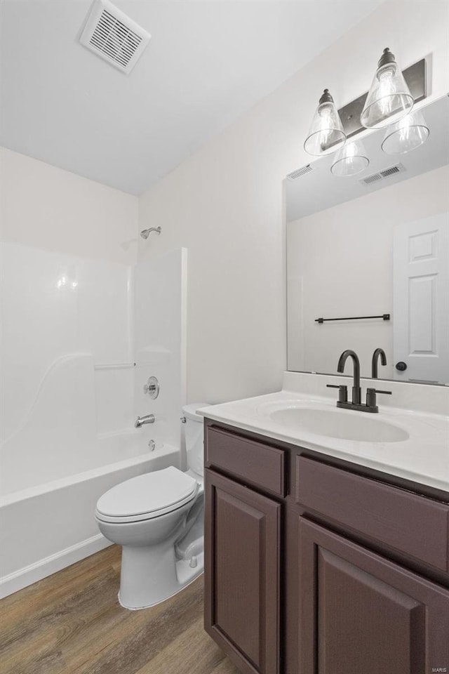 full bath with visible vents, toilet, wood finished floors, and vanity