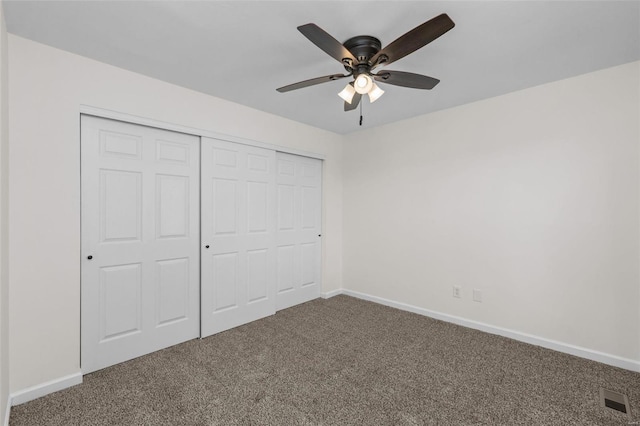 unfurnished bedroom featuring carpet, baseboards, a closet, and ceiling fan