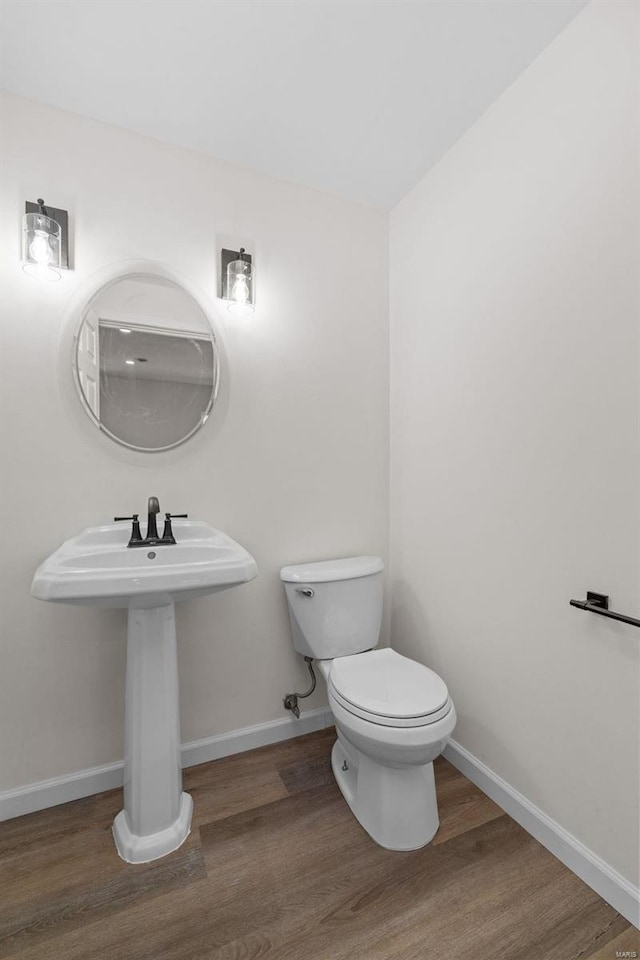 bathroom featuring toilet, baseboards, and wood finished floors