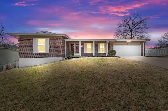 ranch-style house featuring concrete driveway, fence, brick siding, and a lawn