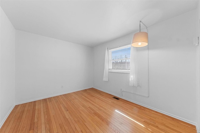 unfurnished room with light wood-style floors and baseboards