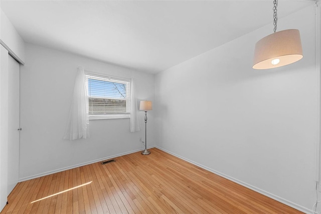 unfurnished bedroom with baseboards, visible vents, a closet, and light wood-type flooring