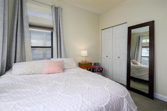 carpeted bedroom featuring baseboards and a closet