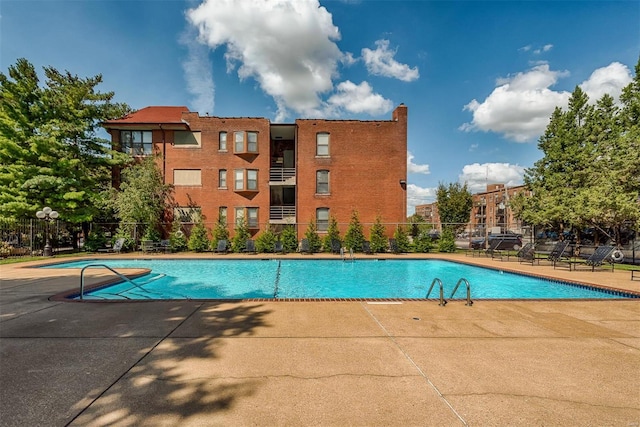 community pool featuring a patio and fence