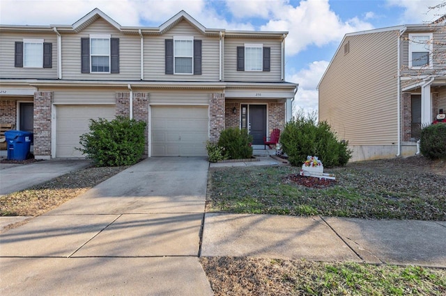 townhome / multi-family property featuring a garage, brick siding, and driveway