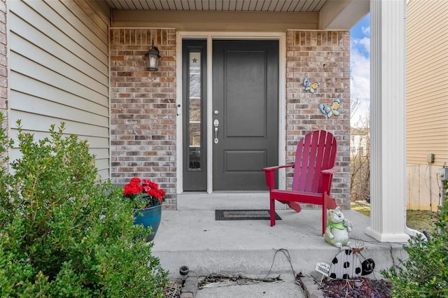 view of exterior entry featuring brick siding