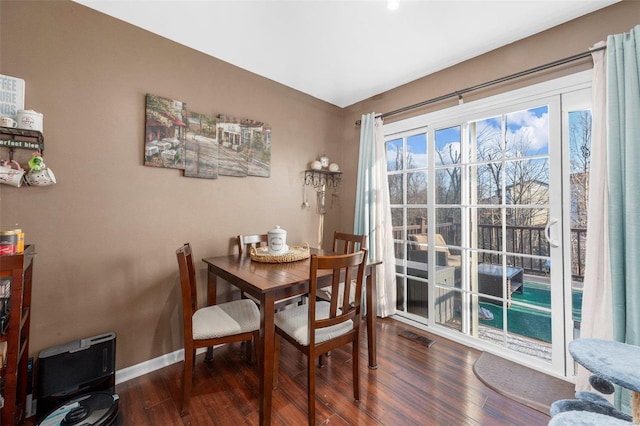 dining space with visible vents, baseboards, and wood finished floors