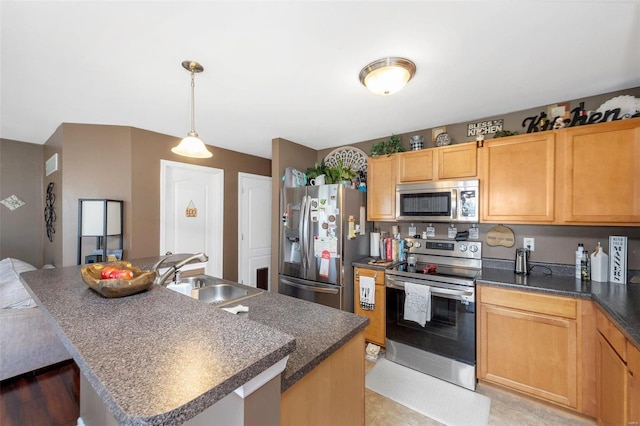 kitchen with a center island with sink, a sink, hanging light fixtures, appliances with stainless steel finishes, and dark countertops