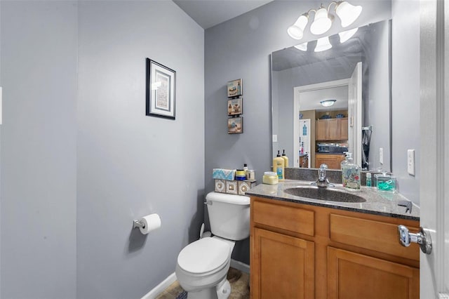 bathroom with vanity, toilet, and baseboards