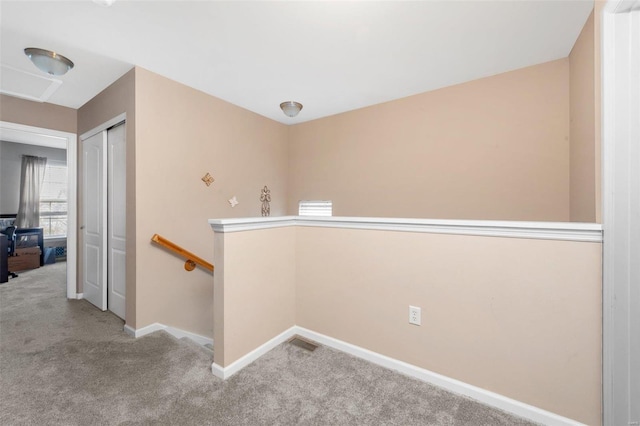 hallway with carpet, an upstairs landing, and baseboards