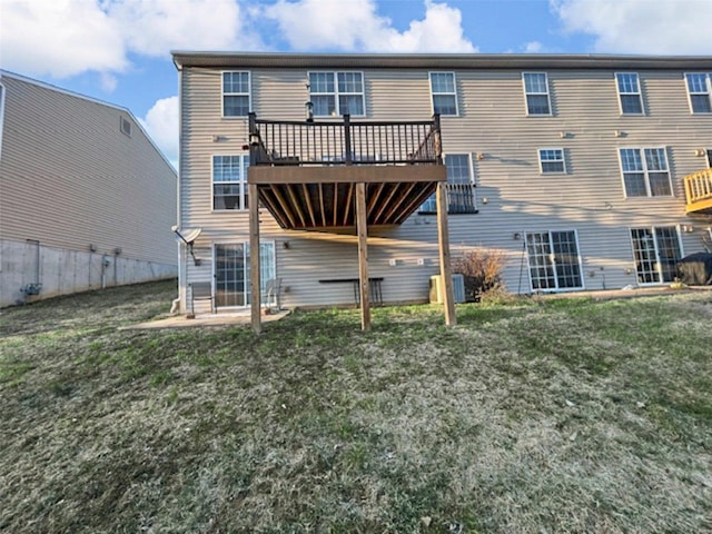 rear view of property with a wooden deck and a yard