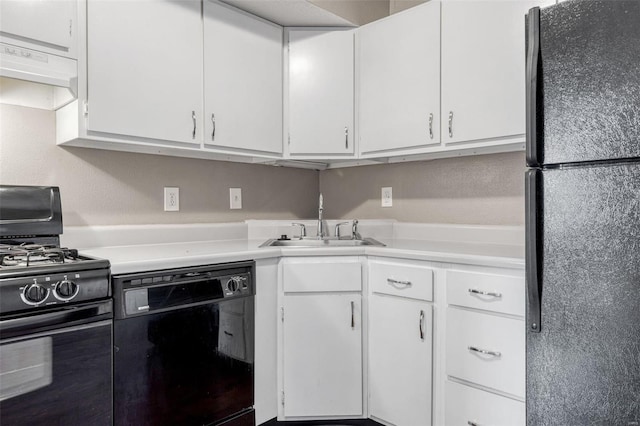 kitchen with white cabinetry, black appliances, light countertops, and a sink