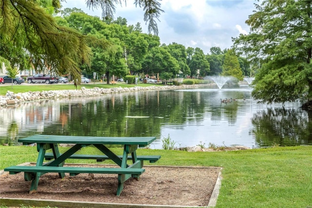 surrounding community with a yard and a water view