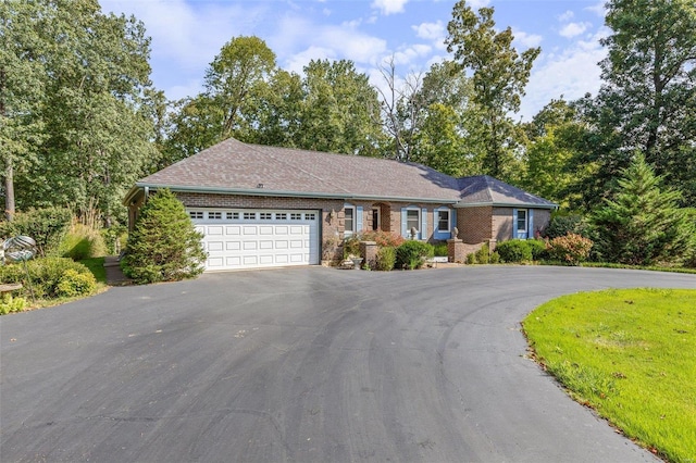 ranch-style house featuring aphalt driveway, brick siding, and a garage