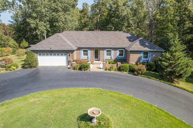 ranch-style house featuring a front yard, an attached garage, brick siding, and driveway