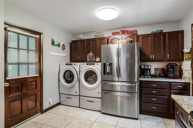 laundry room with baseboards, light tile patterned flooring, laundry area, and washer and clothes dryer